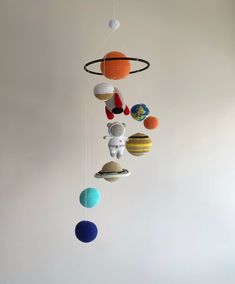 a crocheted mobile with planets hanging from it's sides in a room