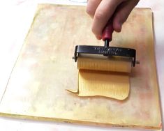 a person is using a roller to make pasta on a cutting board with a knife