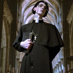 a priest is standing in front of the alter with his cross on his chest and holding a bible