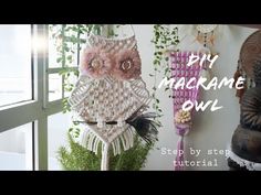 an owl made out of macrame is hanging on the wall next to a potted plant