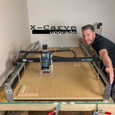 a man standing next to a table with an x - carve upgrade on it