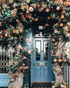 a blue door with flowers growing on it