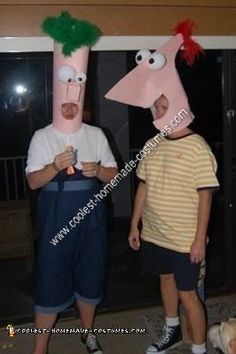 two men in costumes standing next to each other with their heads made out of paper