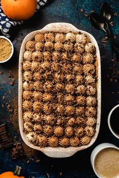 an uncooked cake in a baking dish surrounded by spices and other food items