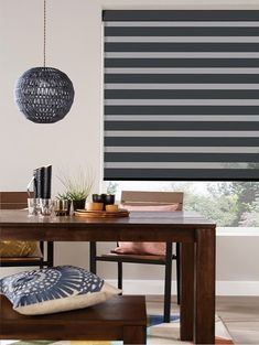 a dining room with a table and chairs in front of a window that has vertical shades on it