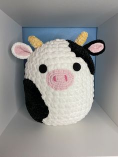 a crocheted cow head in a blue box