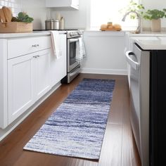 a clean kitchen with white cabinets and wood flooring is seen in this image from the doorway