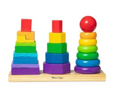 a wooden stacking toy with an apple sitting on it's top next to other toys