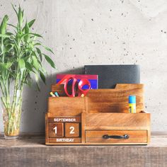 a wooden desk with a plant and calendar on it