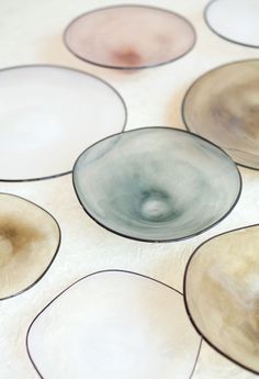 an array of glass bowls sitting on top of a white tablecloth covered in circles