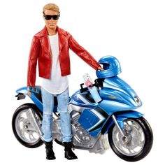 a man standing next to a blue motorcycle with sunglasses on it's head and holding the handlebars