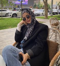 a woman sitting on top of a wooden bench