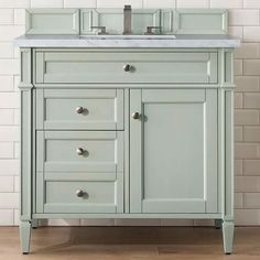 a bathroom vanity with two drawers and a white counter top in front of a brick wall