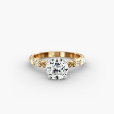 a yellow gold engagement ring with a round brilliant diamond in the center and side stones