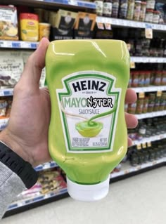 a hand holding a bottle of mayonnaise in a store