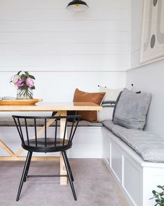 an instagram photo of a table and bench in a small room with white walls