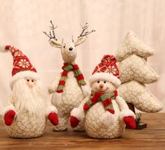 three snowmen with hats and scarves are standing in front of two christmas trees