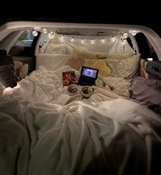 a bed in the back of a truck with lights on it and two laptops