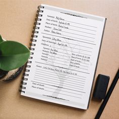 a notepad with writing on it next to a potted plant and black pen