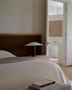 a bedroom with a bed, nightstand and door leading to an outside patio area in the background