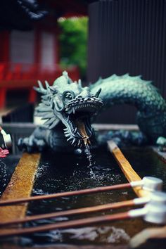 black and white photograph of dragon figurines on top of a table with other items