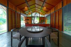 a dining room table and chairs in front of large windows