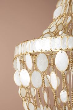 a gold and white chandelier with lots of discs hanging from it's sides