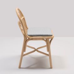 a wooden chair with a blue cushion on it's seat and backrests