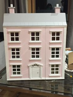 a pink doll house sitting on top of a glass table