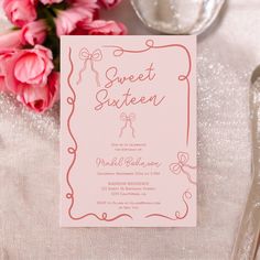 a pink and white wedding suite on a table next to silverware, flowers and napkins