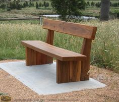 a wooden bench sitting on top of a cement slab