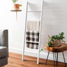 a white ladder next to a chair and potted plant