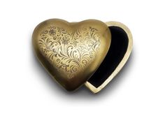 a gold heart shaped box sitting on top of a white surface