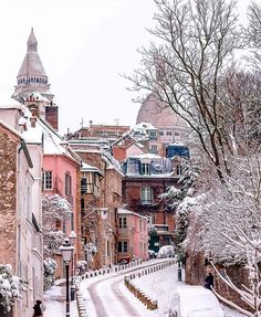 a snow covered street with buildings in the background