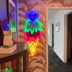 an ice cream sundae neon sign on the wall next to a hallway with palm trees