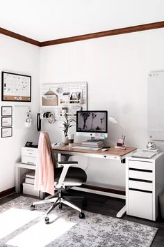 a white desk with two computer monitors on it