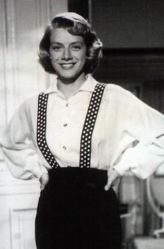 an old black and white photo of a woman in overalls with her hands on her hips