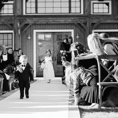 a little boy walking down the aisle at a wedding