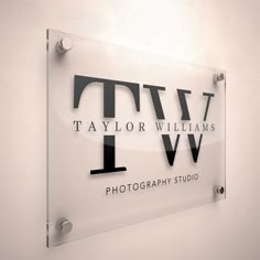 a glass sign that says taylor williams photography studio on the side of a white wall