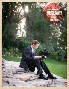 a man in a suit is sitting on some steps and looking down at his book