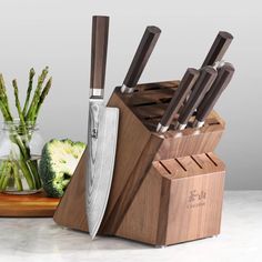 a wooden block with knives and vegetables in it