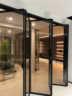 the inside of a store with glass doors and plants in it's display cases