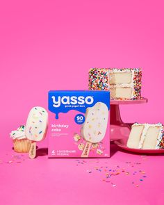 a box of yusso birthday cake with sprinkles on it and three cakes in the background