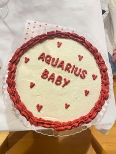 a cake with the words aquarius baby written on it and hearts in the middle