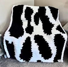 a black and white crocheted blanket sitting on the floor