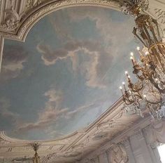 a chandelier hanging from the ceiling in a room with a painting on it