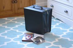 a suitcase sitting on the floor next to some dvd's