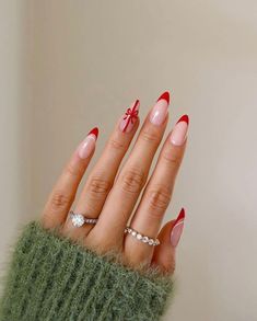 Sophisticated and festive, these nails feature sleek red French tips paired with a single accent nail designed as a wrapped gift. The delicate red bow on a nude base adds a chic and playful element to the overall look. This manicure is perfect for anyone looking to combine elegance with the joy of Christmas gift-giving. Fake Nails With Glue, Christmas Nails Acrylic, Nail Arts, Artificial Nails