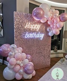 a birthday party with pink and white balloons