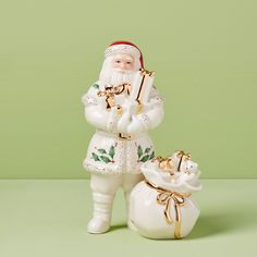 a white santa clause figurine holding a bell